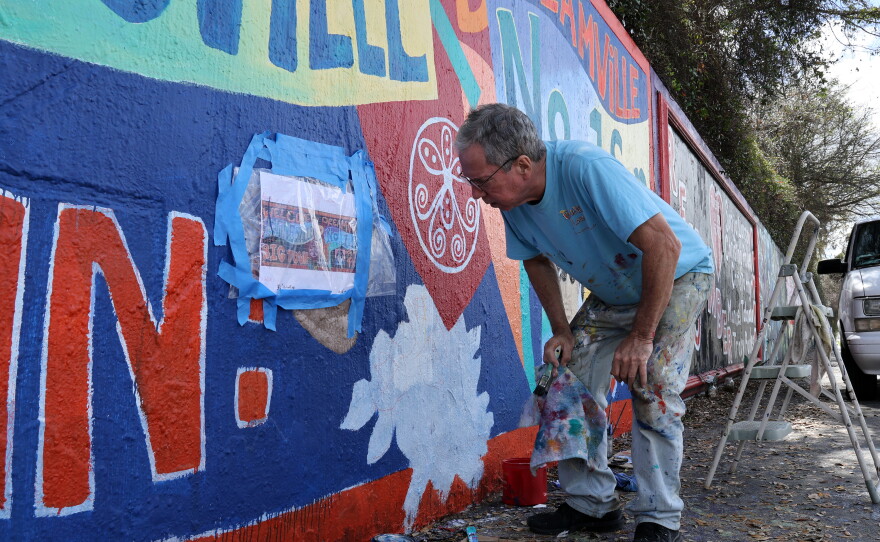 A Gainesville artist painting a bright section of the 34th Street Wall